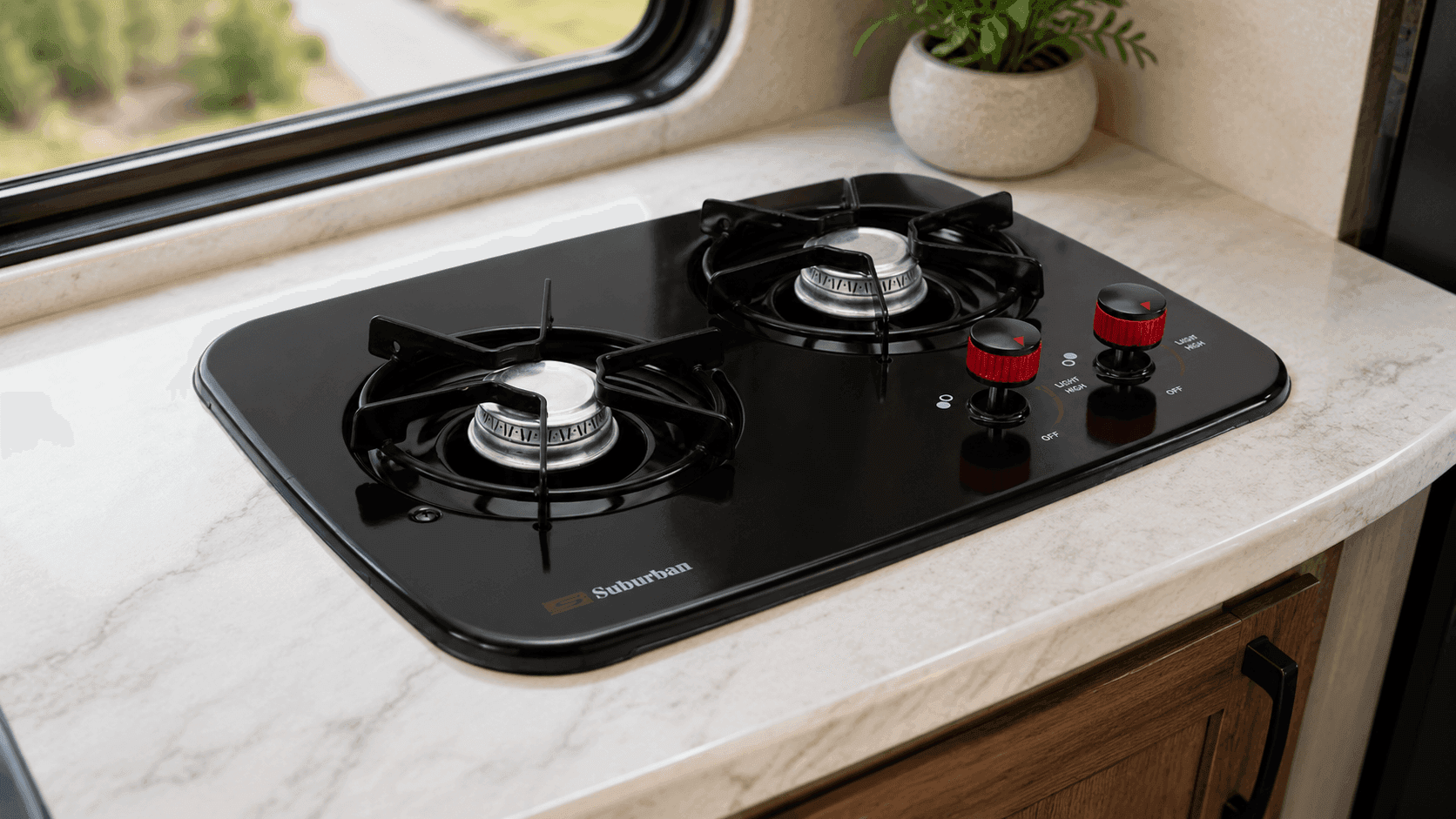 Alt text: Black RecPro RV Suburban 2 Burner Propane Gas Cooktop installed in compact camper kitchen interior